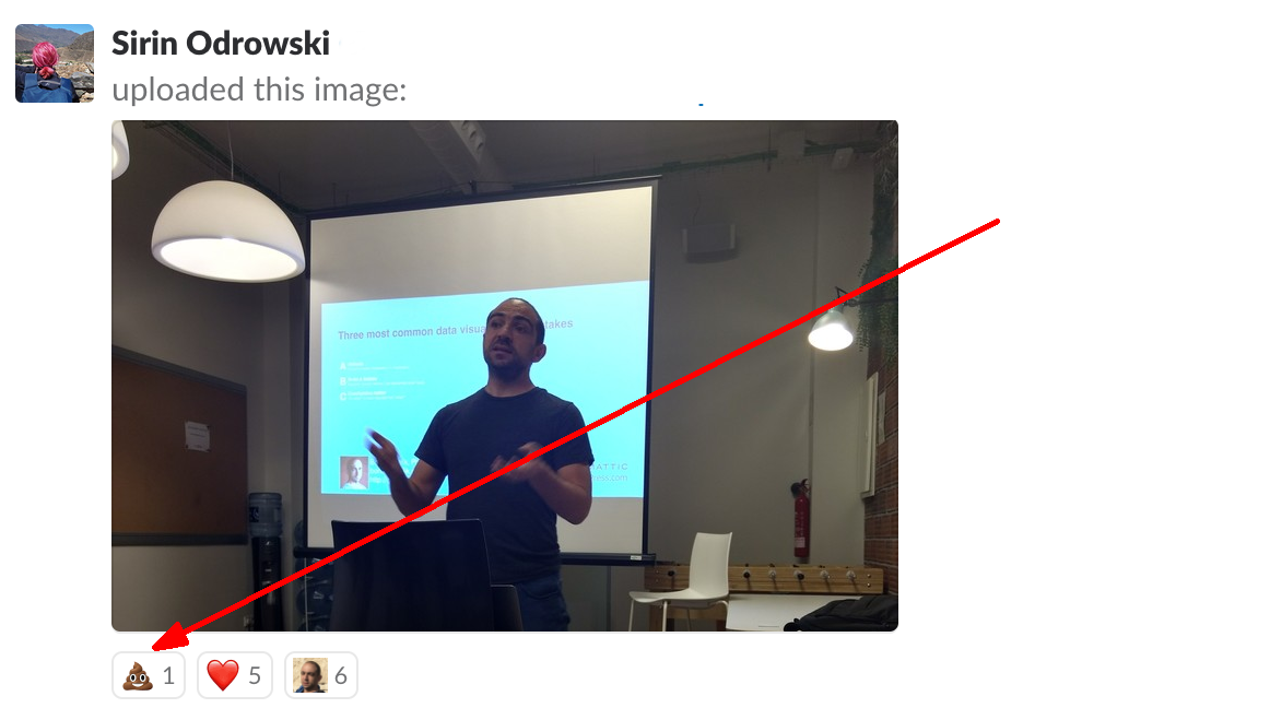 Slack screenshot: Photo of me delivering a presentation. One "smiling poop emoji" attached to the photo as a reaction